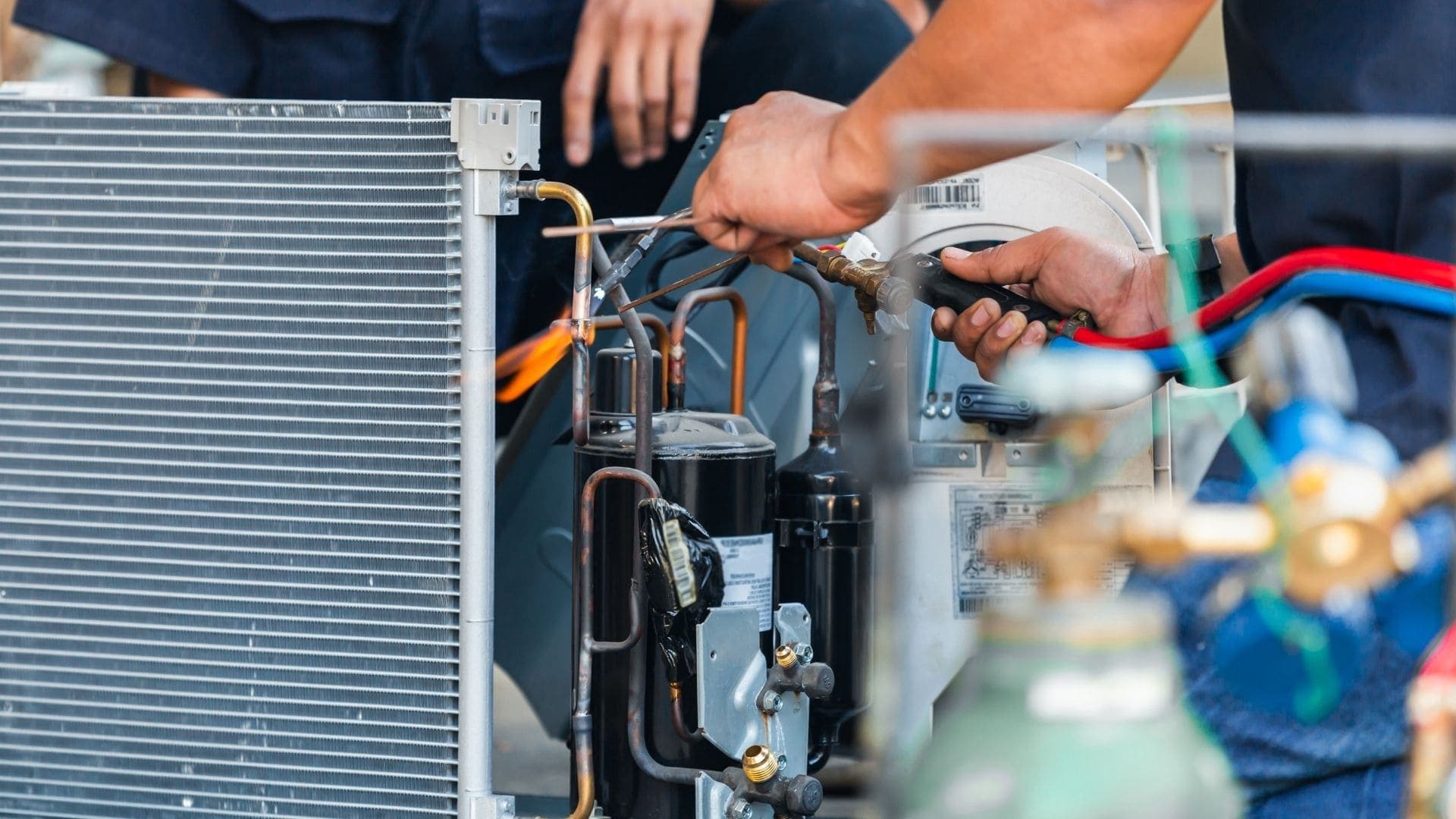 Technician brazing refrigerant lines during an HVAC repair