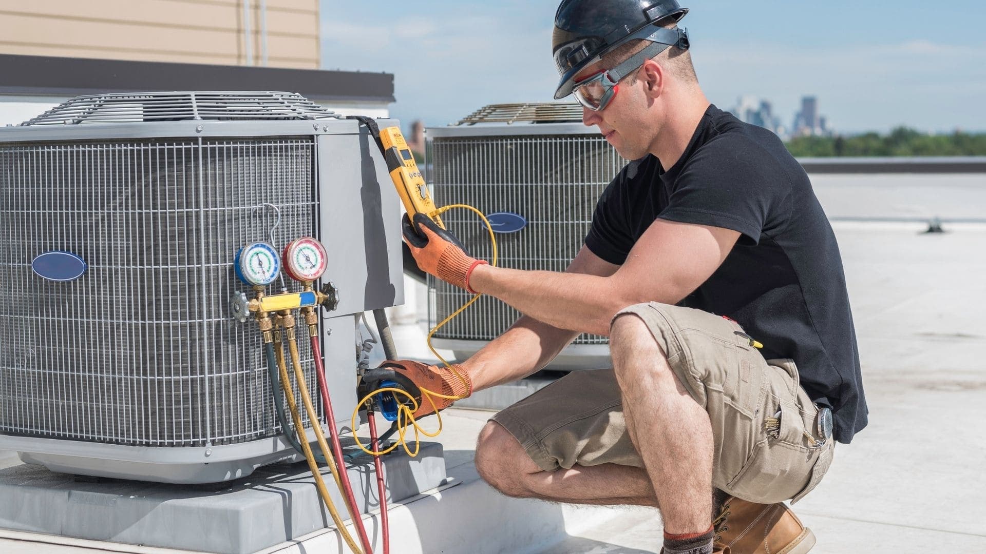 Wheelhouse technician testing rooftop AC condensers with diagnostic gauges