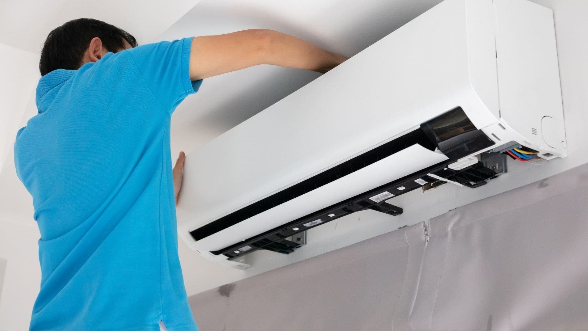 Technician servicing a ceiling vent and ductwork