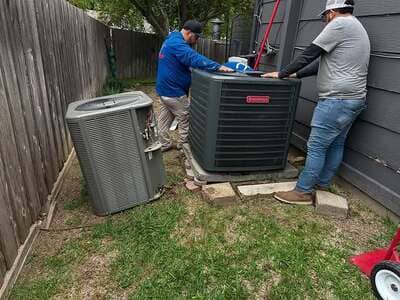 Technician servicing an outdoor AC condenser