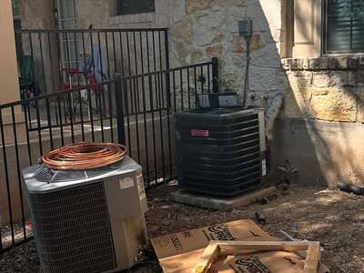 Newly installed outdoor AC condenser by a fence