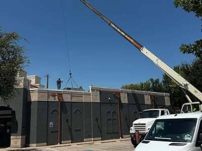 Crane lifting a rooftop HVAC unit on a commercial install